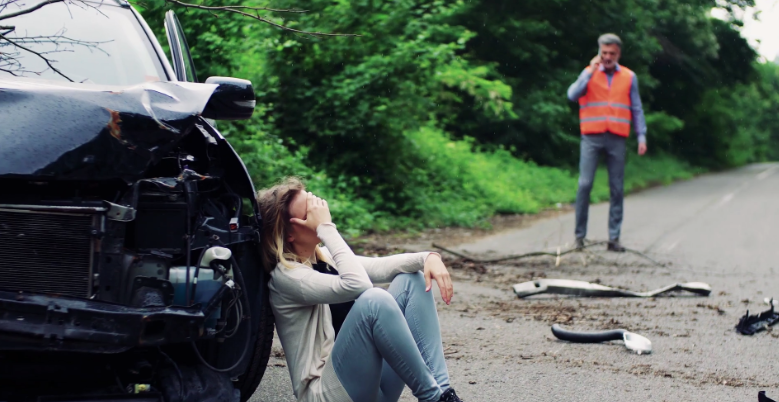 mujer lamentando un choque de su automovil por un accidente en la via publica