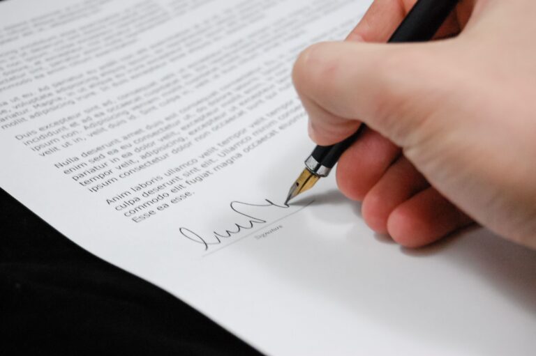 Persona firmando un documento de consentimiento informado con pluma fuente