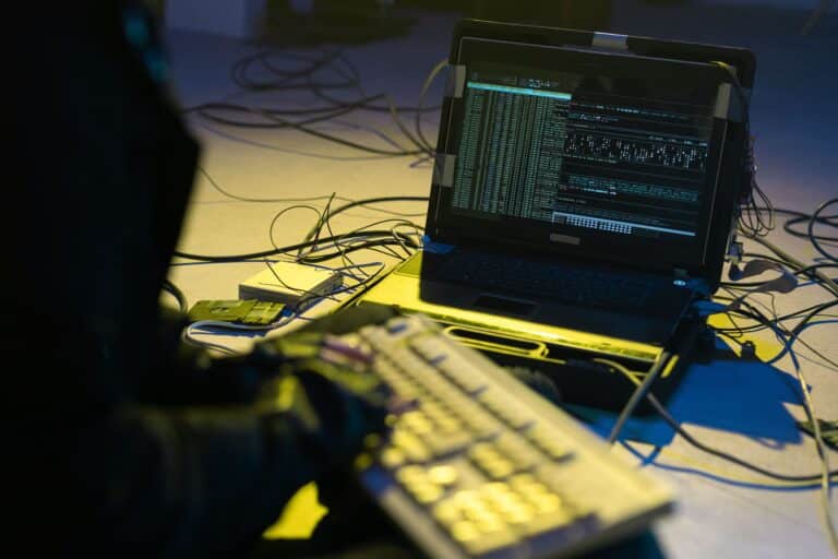 Especialista trabajando en una notebook durante un análisis de informática forense