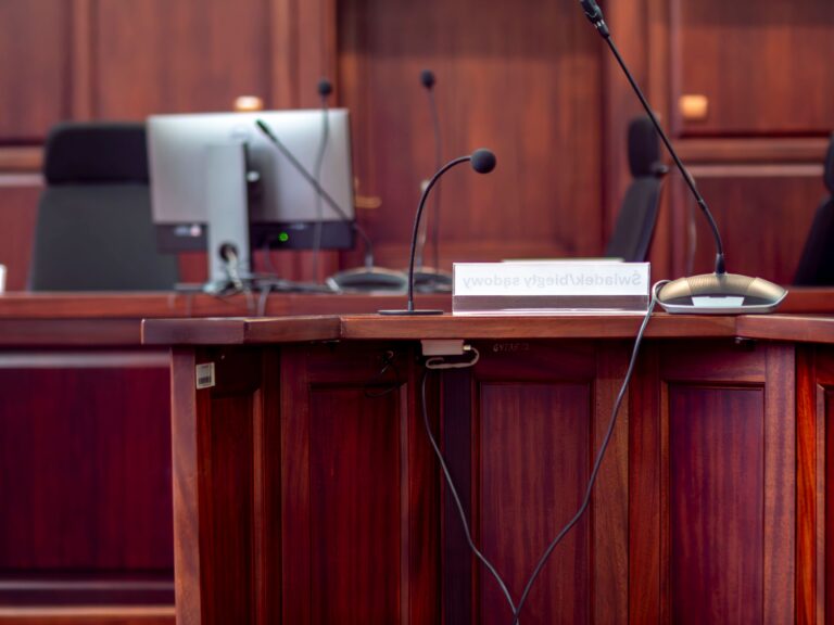 Atril con micrófonos en una sala de audiencias, listo para el interrogatorio a un perito