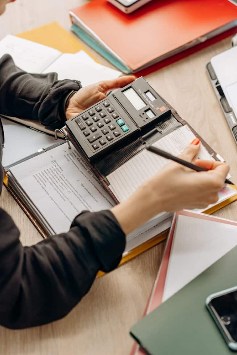 Manos utilizando una calculadora sobre documentación contable