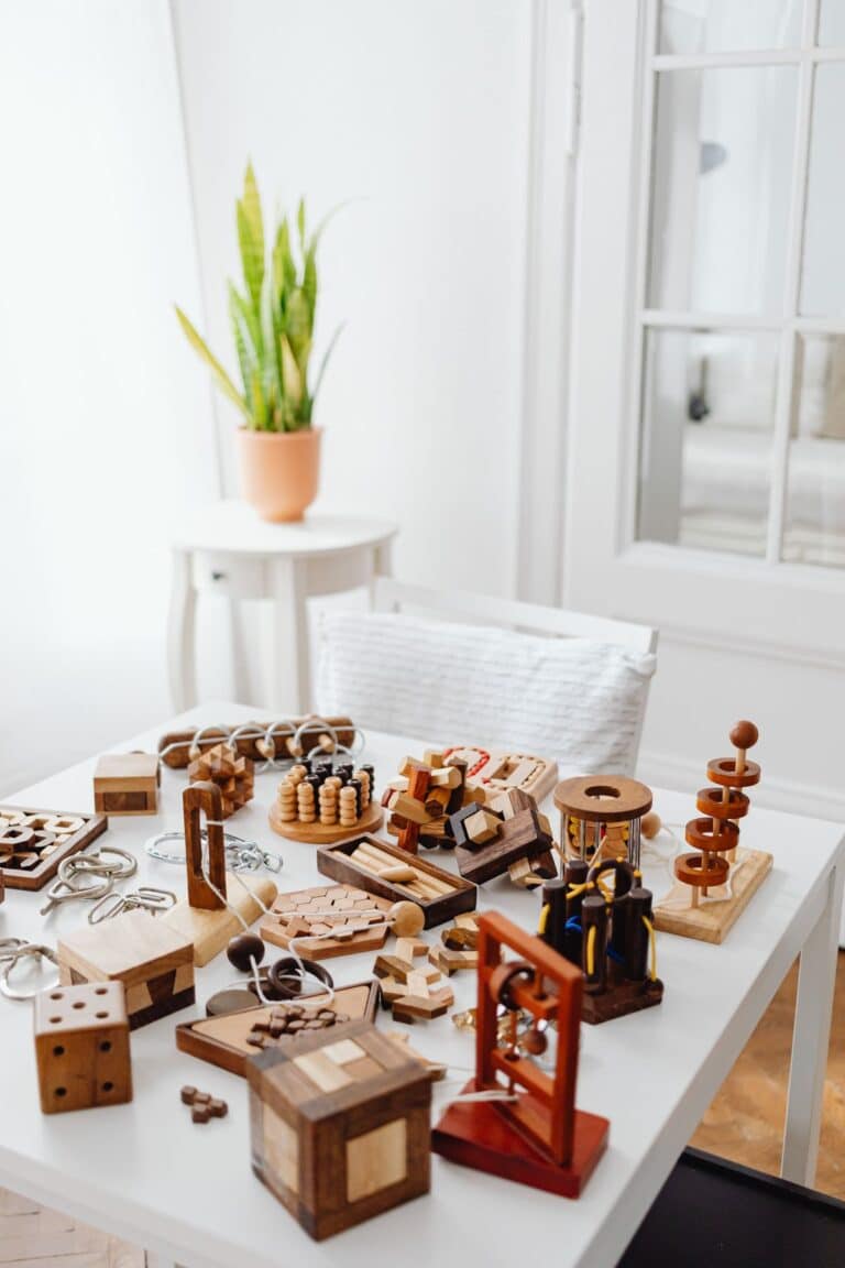 Variedad de rompecabezas y juegos de ingenio de madera sobre una mesa, utilizados en test de inteligencia