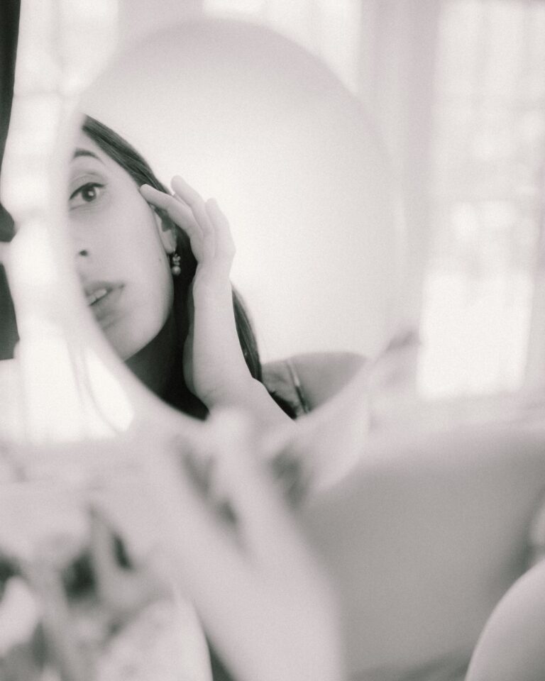 Mujer observando su propio reflejo en un espejo, fotografía en blanco y negro sobre el test de narcisismo