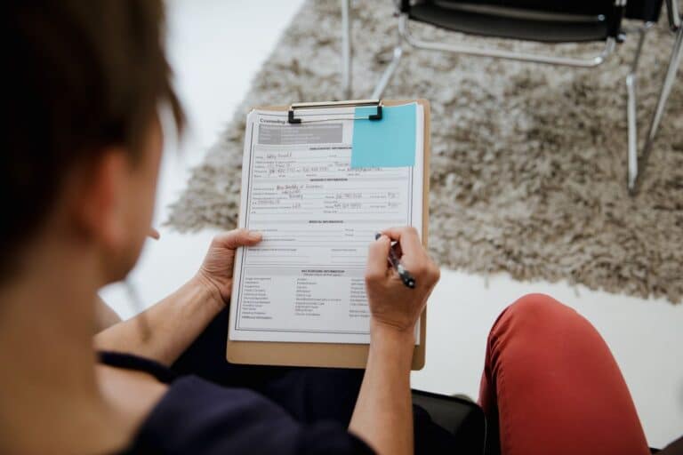 Persona completando un formulario de admisión en una tablilla durante una consulta psicológica